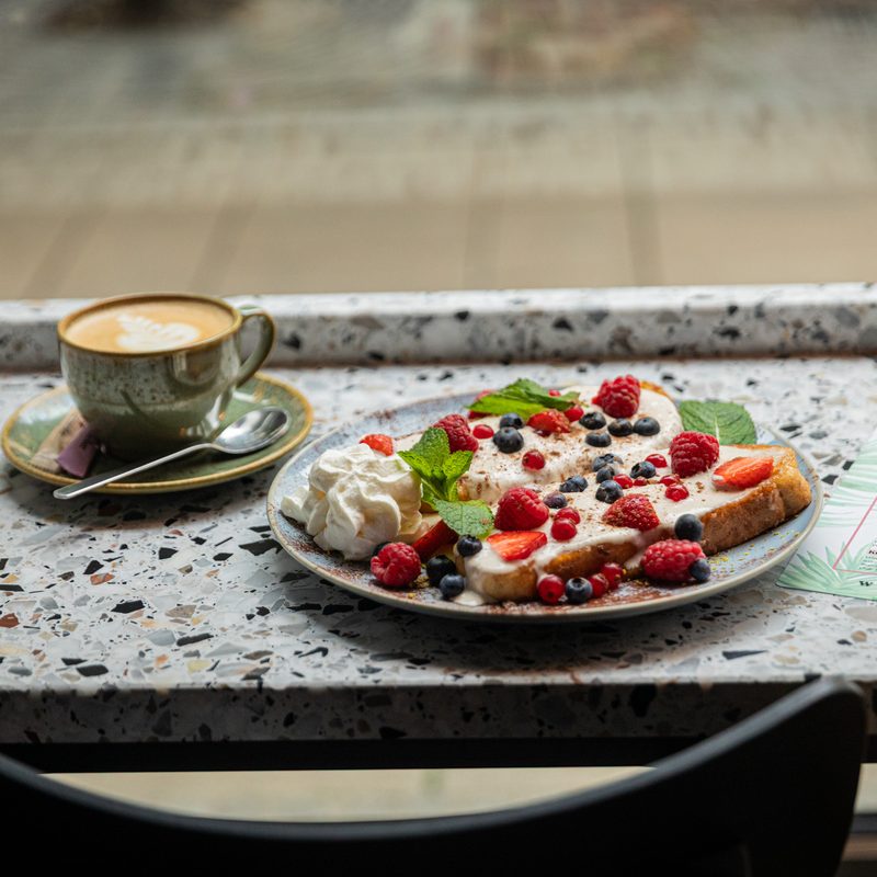 Cappuccino und Kuchen am Fensterplatz